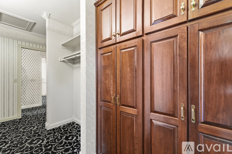 A room with a black and white floor and wooden cabinets.