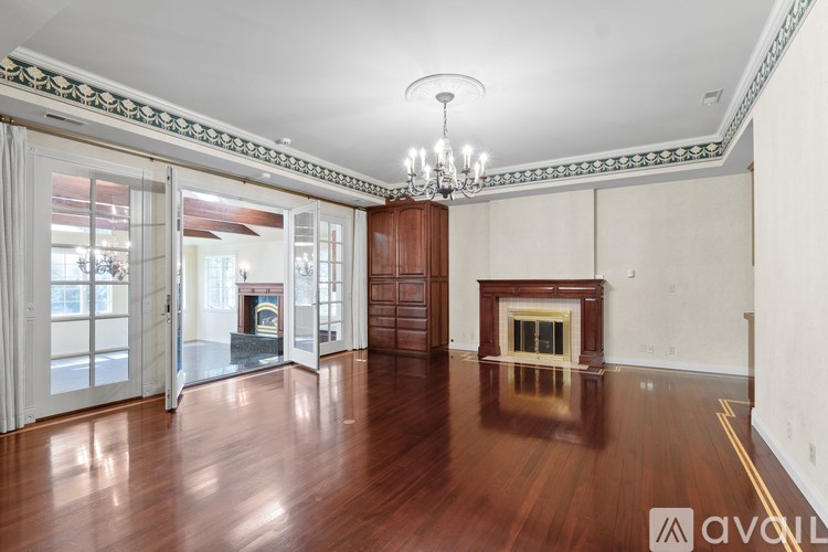 A large empty room with wooden floors and a chandelier.