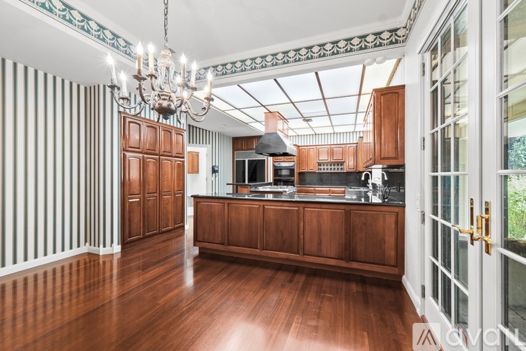 A kitchen with wooden cabinets and a chandelier.