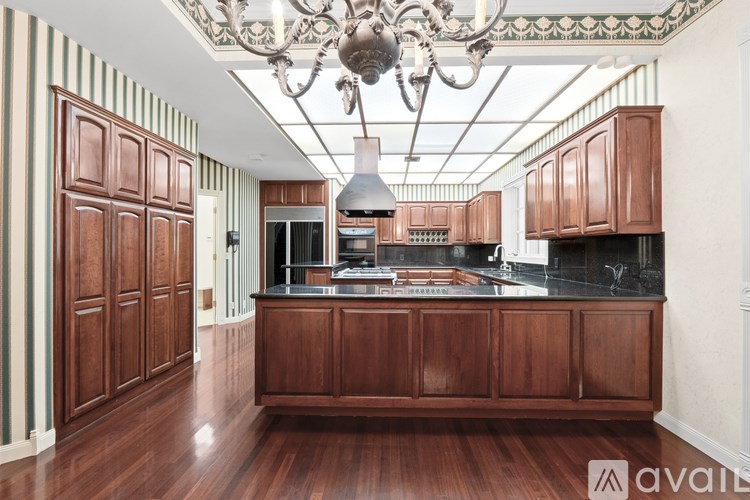 A kitchen with wooden cabinets and a chandelier.