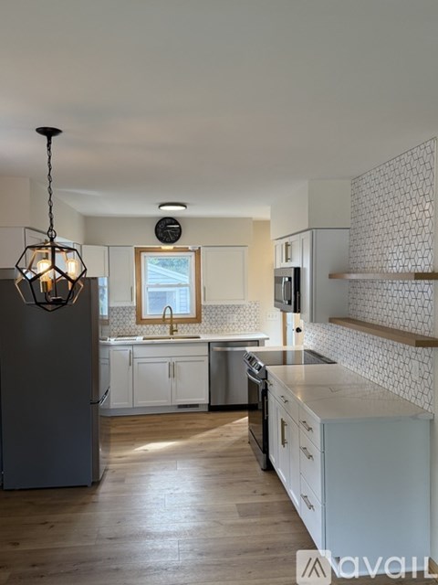A kitchen with a refrigerator, sink, and stove.