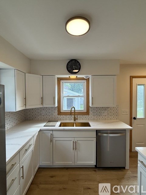 A kitchen with white cabinets and a stainless steel dishwasher.