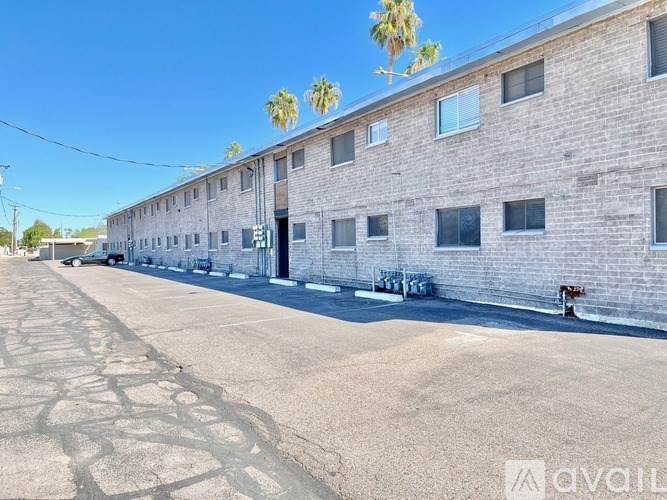 A long building with a lot of windows and a tree in front.