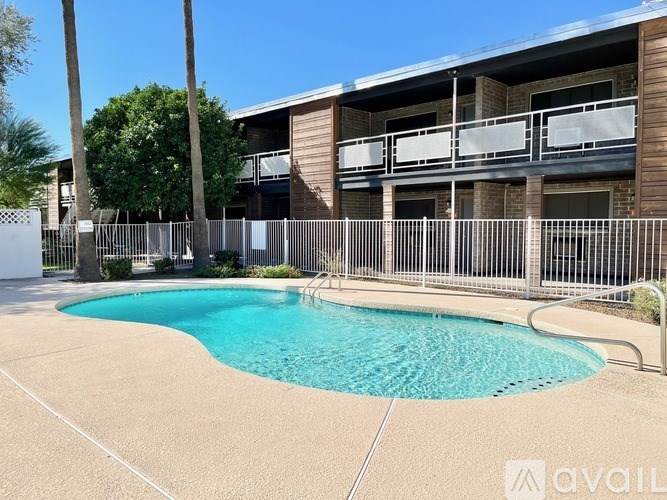 A pool in front of a building with a fence around it.