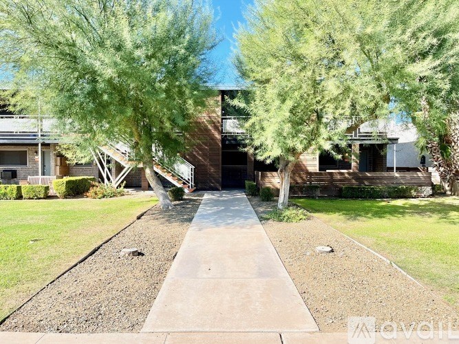 A house with a driveway and trees in front.