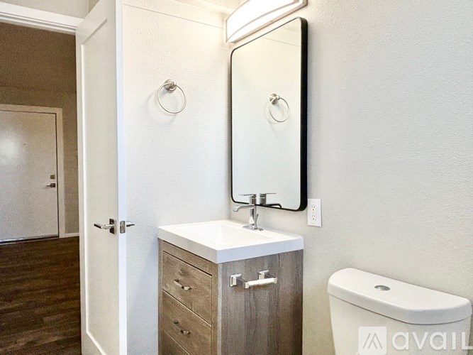 A bathroom with a sink, mirror, and toilet.