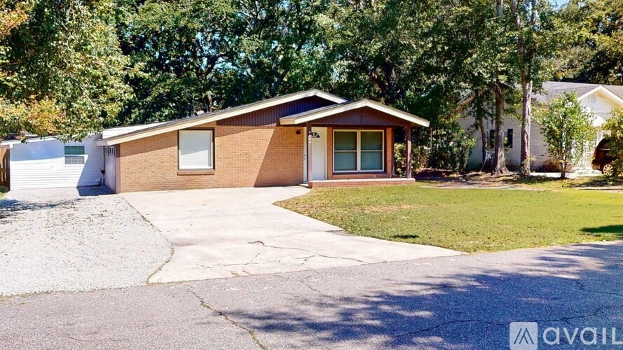 A house with a brown roof and a white garage door is surrounded by trees.
