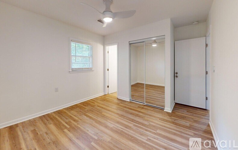 A room with wooden flooring and a ceiling fan.