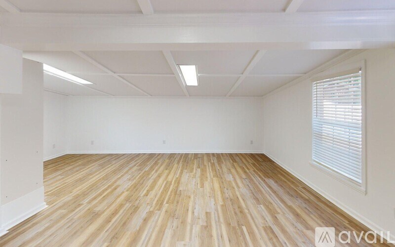 A room with wooden flooring and white walls.