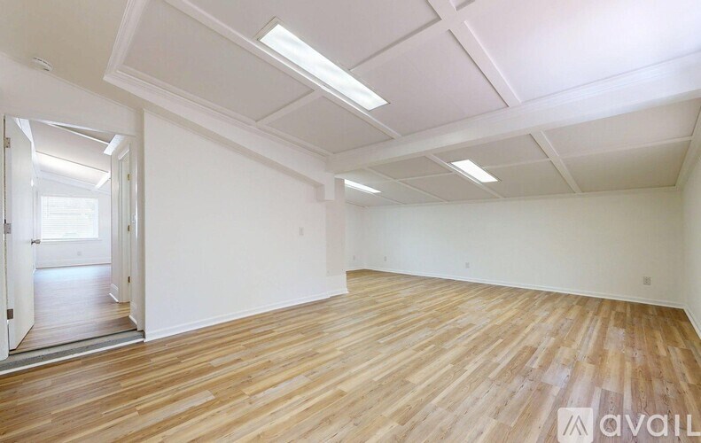 A room with wooden flooring and white walls.