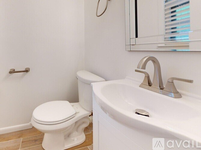 A white toilet and sink in a bathroom.