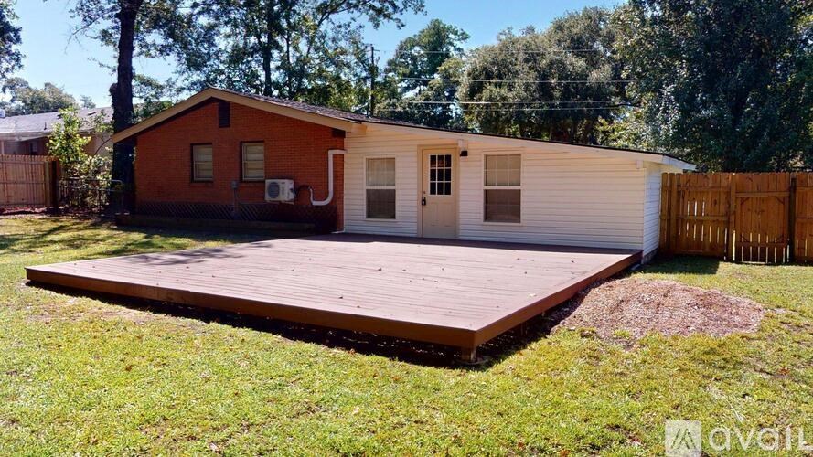 A red house with a white garage door is surrounded by a wooden fence.