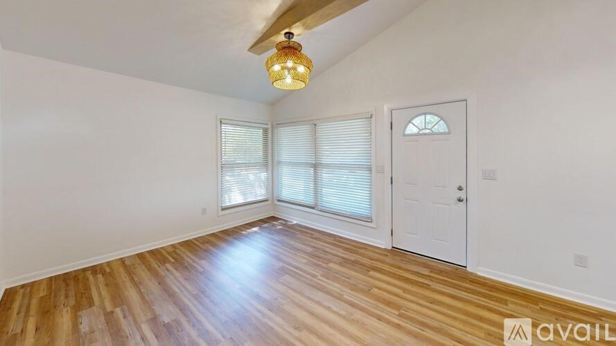 A room with wooden flooring and a white door.