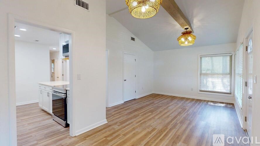 A kitchen with white cabinets and a wooden floor.