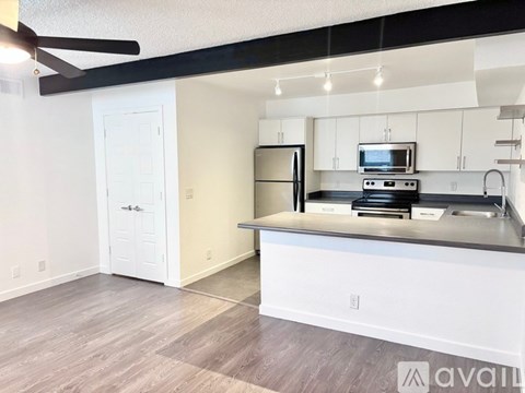 A kitchen with a refrigerator, microwave, and oven.