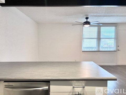 A room with a stainless steel countertop and a ceiling fan.