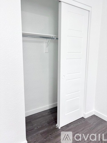 A white closet with a hanger on the rod.
