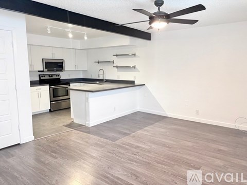 A kitchen with a white island and a ceiling fan.