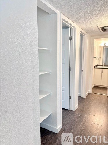 A white pantry with a white door and shelves.