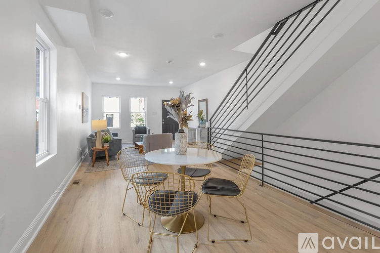 A modern dining room with a round table and chairs.