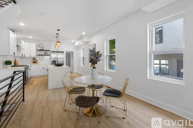 A modern kitchen with a dining table set up with chairs.