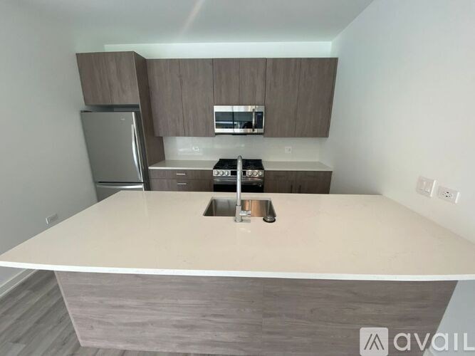 A kitchen with a white countertop and wooden cabinets.