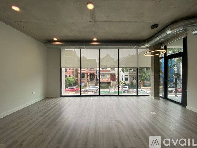 A spacious room with large windows overlooking a street.