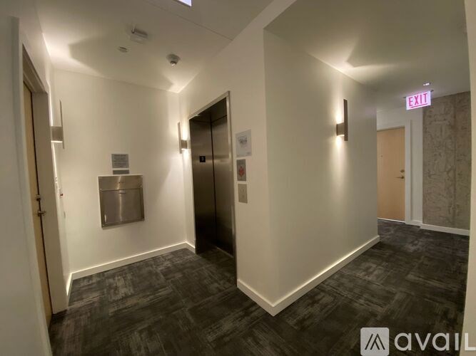 A hallway with a red exit sign above the door.
