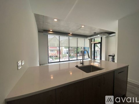 A kitchen with a sink and a window overlooking a street.