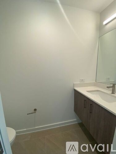 A bathroom with a toilet, sink, and mirror.