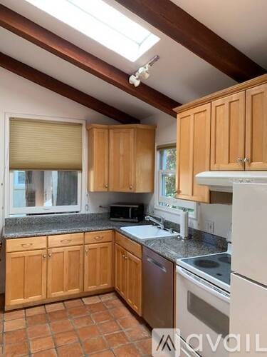 A kitchen with wooden cabinets and a skylight.