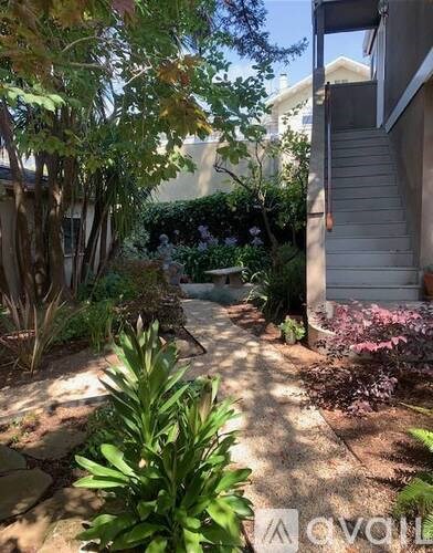 A garden with a pathway and a house in the background.