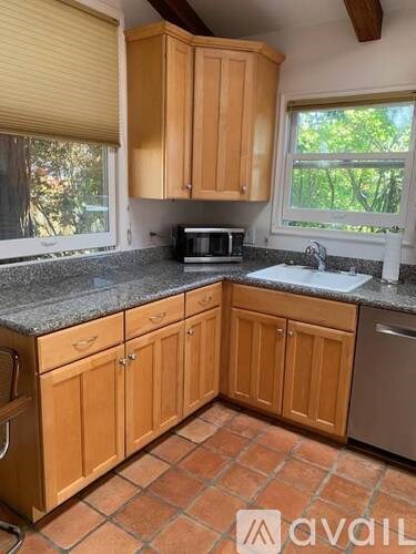 A kitchen with wooden cabinets and a tiled floor.