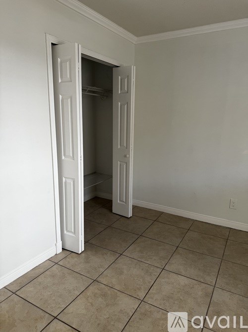 A room with a white door and tiled floor.