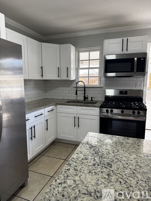 A kitchen with granite countertops and stainless steel appliances.