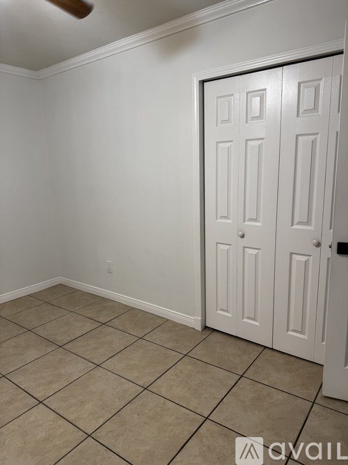 A room with a white door and tiled floor.