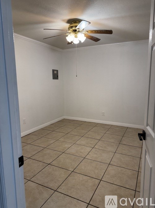 A room with a ceiling fan and tile flooring.