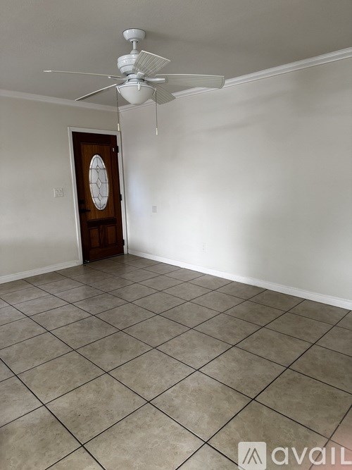 A room with a ceiling fan and a door.