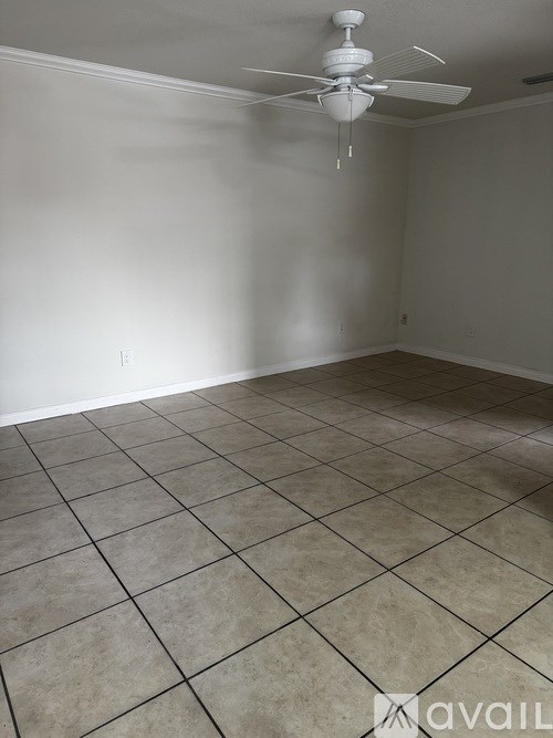 A room with a ceiling fan and tile flooring.
