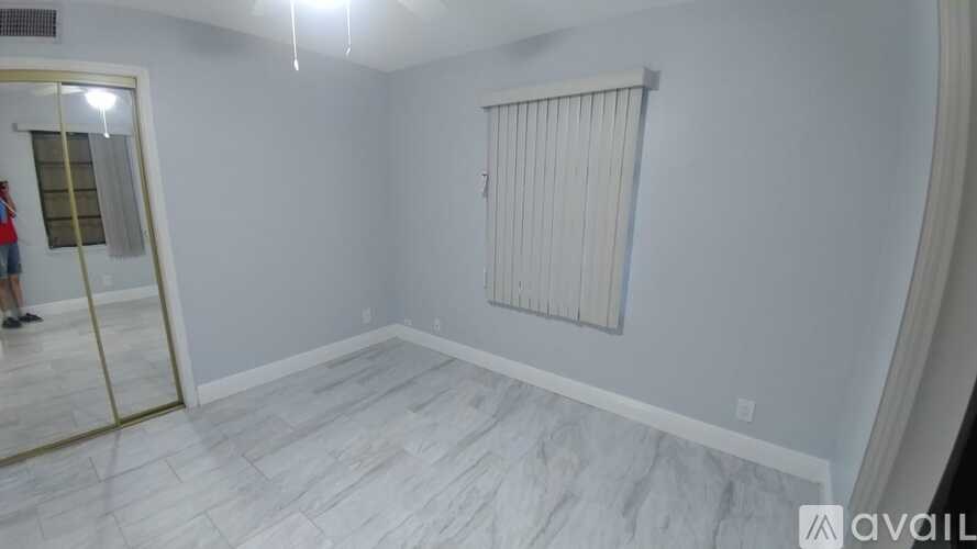 A room with a marble floor and a window with blinds.