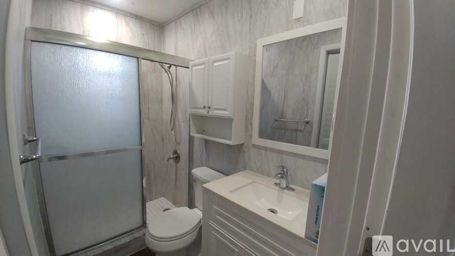 A bathroom with a toilet, sink, and shower.