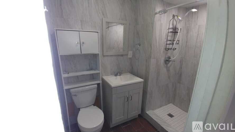 A bathroom with a toilet, sink, and shower.