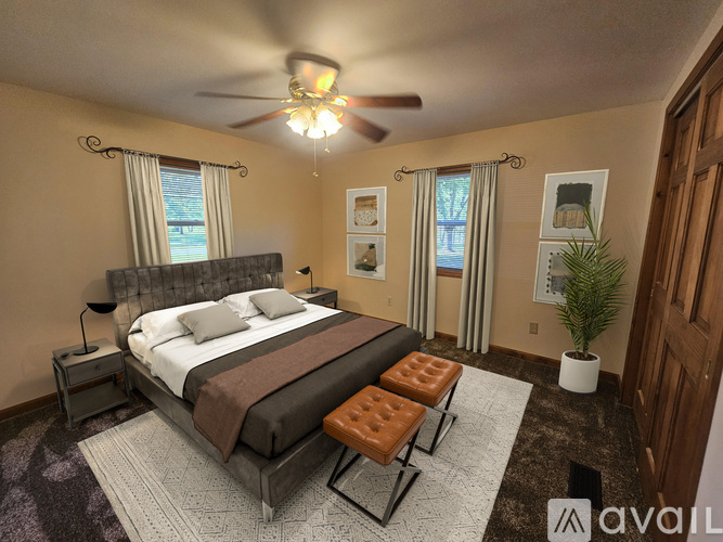 A bedroom with a large bed and a ceiling fan.