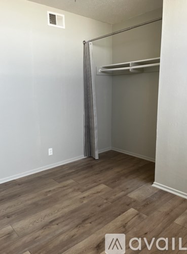 A room with a bunk bed and wooden flooring.