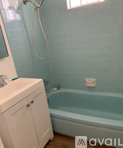 A white bathroom cabinet with a sink and a bathtub.