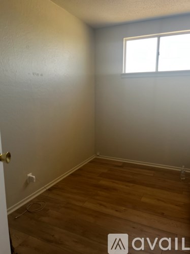 A room with wooden flooring and a window.
