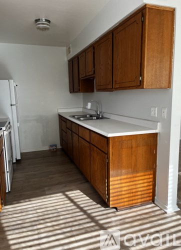 A kitchen with wooden cabinets and a white fridge.