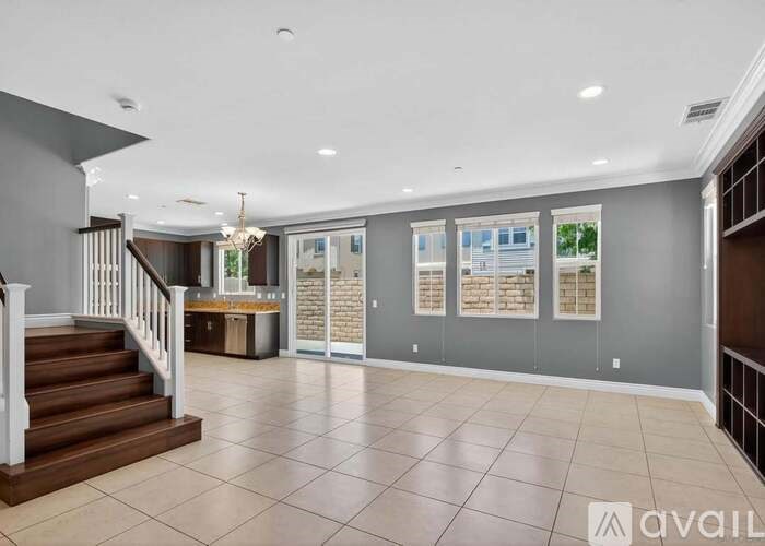 A spacious living room with a staircase leading to the upper floor.