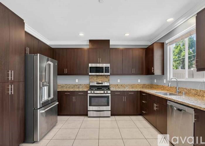 A kitchen with brown cabinets and stainless steel appliances.