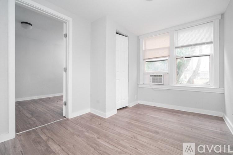 A room with a window and wooden flooring.